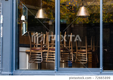 Window of an empty restaurant forced to close amid COVID-19 pandemic 72665899
