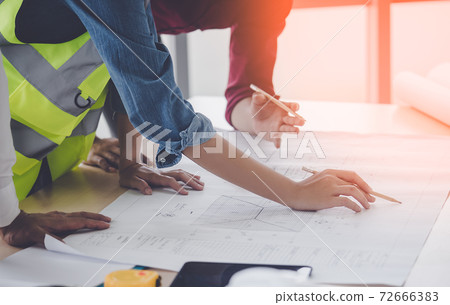 Construction team engineer and architect is brainstorming on working table with building plan Construction team engineer and architect is brainstorming on working table with building plan 72666383