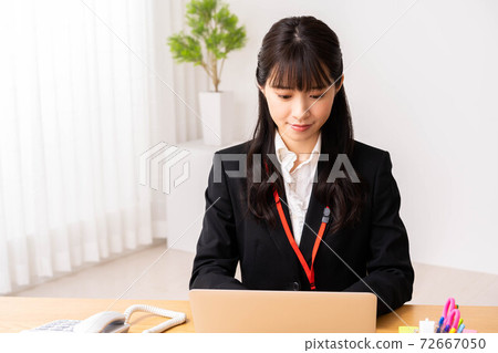 使用一台筆記本電腦的年輕女子在辦公室 使用一台筆記本電腦的年輕女子在辦公室 72667050