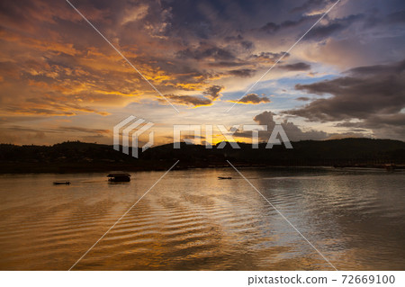 A colorful sunset is reflecting on water in dam 72669100