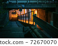 Handrails and guardrail shadows against a red tunnel background 72670070