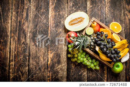 Various ripe fruits in a wooden box. 72671488