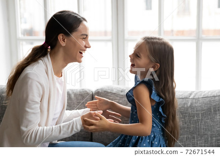 Close up overjoyed mother and little daughter playing patty cake Close up overjoyed mother and little daughter playing patty cake 72671544