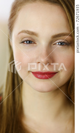 Head shot of a smart confident smiling millennial european woman standing with folded arms at home 72671935