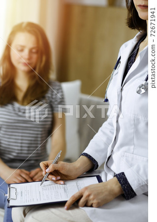 Close-up of woman-doctor and patient discussing current health examination while sitting indoors. Stay at home concept during Coronavirus pandemic and self isolation quarantine. Covid 2019 72671941