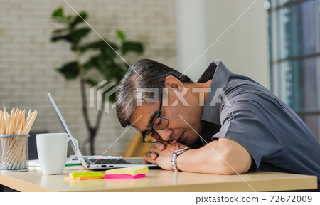 businessman tired overworked he sleeping over a laptop computer 72672009