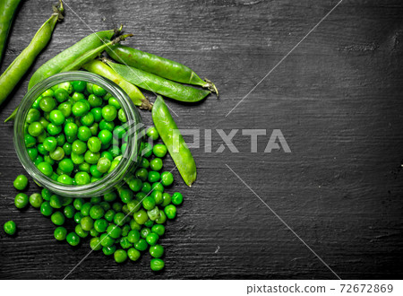 Fresh green peas in glass jar. On black chalkboard. 72672869