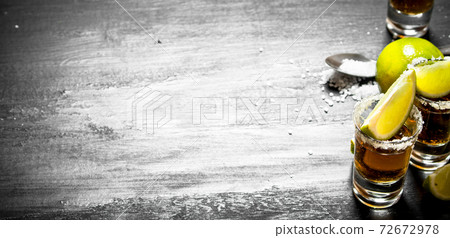 Tequila with salt and lime slices. 72672978