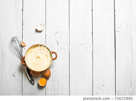 Mayonnaise in bowl with whisk. 72672980