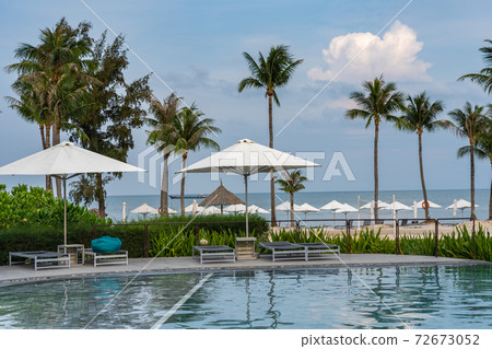 Beautiful swimming pool next to the palm tree beach 72673052