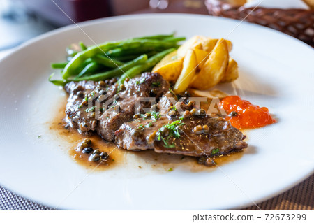 Beef steak with mushroom sauce and roasted potatoes Beef steak with mushroom sauce and roasted potatoes 72673299