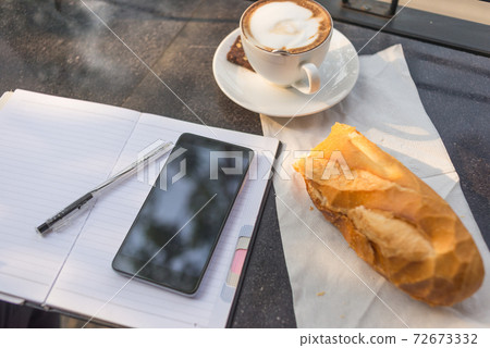 Morning working day with smartphone, hot coffee and bread 72673332