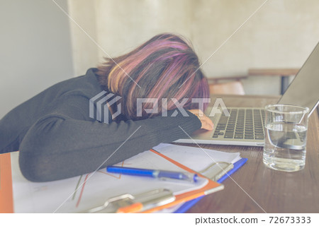 Young staff sleeping on laptop and documents at workplace Young staff sleeping on laptop and documents at workplace 72673333