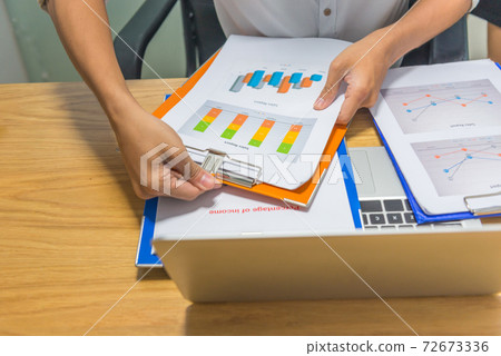 Man hand holding financial report in the office Man hand holding financial report in the office 72673336