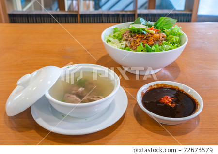 Delicious pork noodle soup and herbs in Asian restaurant 72673579