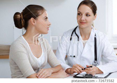Doctor and patient are sitting and discussing health examination results in clinic office. Health care, medicine and good news concepts 72673582