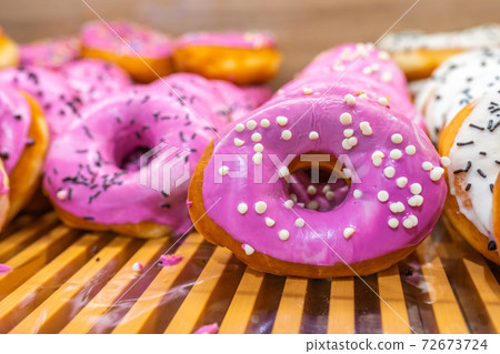 Pink glazed donut topped with white chocolate chips at bakery Pink glazed donut topped with white chocolate chips at bakery 72673724