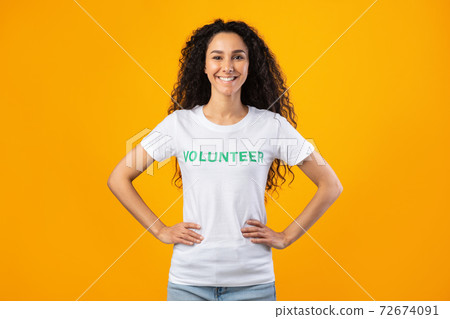 Enthusiastic Volunteer Woman Posing Smiling Standing Over Yellow Studio Background Enthusiastic Volunteer Woman Posing Smiling Standing Over Yellow Studio Background 72674091