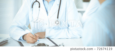 Unknown woman-doctor and patient sitting at the table. Very good news and high level medical service concept 72674119