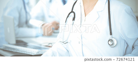 Group of unknown doctors discussing problems to stop coronavirus pandemic while sitting at meeting in clinic, close-up . Medicine concept Group of unknown doctors discussing problems to stop coronavirus pandemic while sitting at meeting in clinic, close-up . Medicine concept 72674121