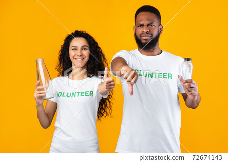 Two Volunteers Holding Glass And Plastic Bottles Over Yellow Background 72674143
