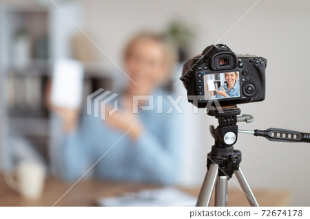 Female vlogger making video review of new gadget, selective focus of camera wih recording on screen, copy space Female vlogger making video review of new gadget, selective focus of camera wih recording on screen, copy space 72674178