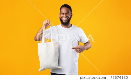 Smiling Black Guy Holding Eco Bag Standing Over Yellow Background 72674180
