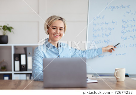 Young university teacher giving mathematics class online from home, explaining logarithms to college students 72674252