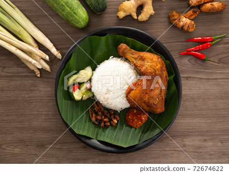 Nasi Kukus is usually comprising freshly steamed rice and crispy fried chicken Nasi Kukus is usually comprising freshly steamed rice and crispy fried chicken 72674622