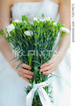 Bride on wedding dress is holding  bouquet of flowers 72674671