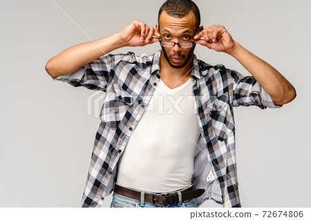 Portrait of a young african american man wearing glasses with surprised expression on face 72674806