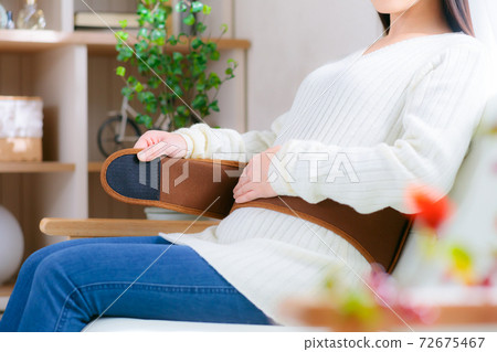 A woman who warms her waist by wrapping a warm belt 72675467