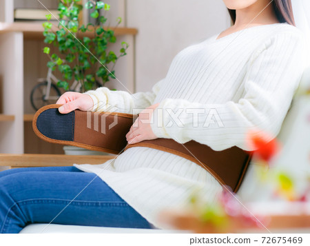 A woman who warms her waist by wrapping a warm belt 4: 3 A woman who warms her waist by wrapping a warm belt 4: 3 72675469