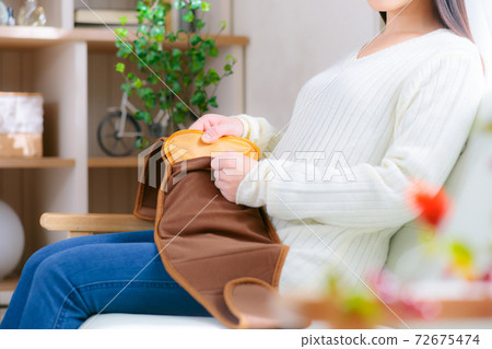 A warm female supporter belt with a hot water bottle 72675474