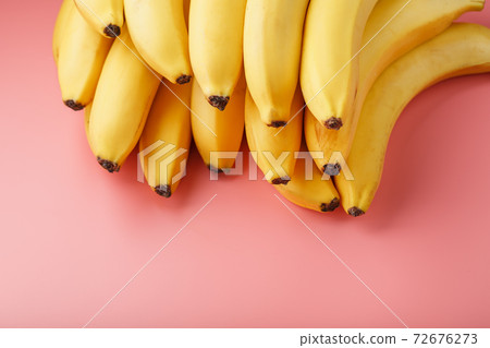 Fresh bunch of yellow bananas isolated on a pink background. 72676273