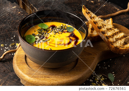 Pumpkin cream soup with grilled white bread. Pumpkin seed, balsamic, fried quinoa. Diet vegan hot boiled vegetable dish. Pumpkin cream soup with grilled white bread. Pumpkin seed, balsamic, fried quinoa. Diet vegan hot boiled vegetable dish. 72676561