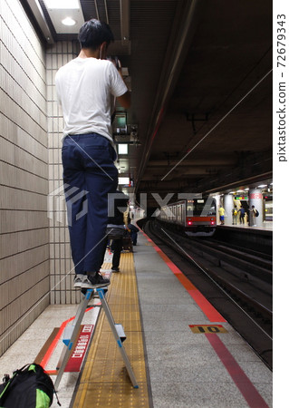 Photographer using a stepladder on a station platform Photographer using a stepladder on a station platform 72679343