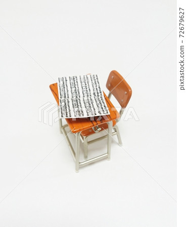 Sheet music placed on the school desk 72679627