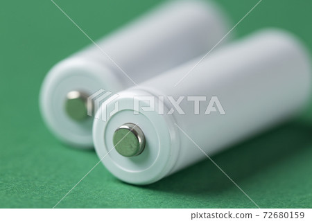 White AA batteries on a green background. The most popular size of accumulators. White AA batteries on a green background. The most popular size of accumulators. 72680159