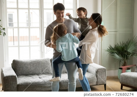 Overjoyed family with kids having fun, dancing, moving to music Overjoyed family with kids having fun, dancing, moving to music 72680274