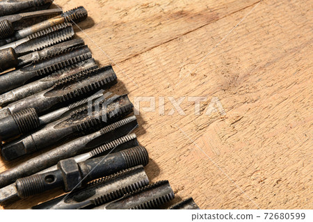 Old vintage hand tools - drills and threading die on a wooden background Old vintage hand tools - drills and threading die on a wooden background 72680599