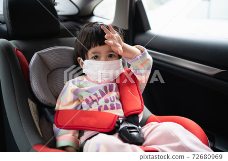 Cute baby sitting in a car safety seat Cute baby sitting in a car safety seat 72680969