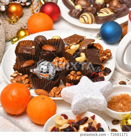 sweet food top view background for merry christmas or new year holiday decoration - chocolate candies, tangerines, cookies, marshmallow and cocoa latte on white wood 72681171