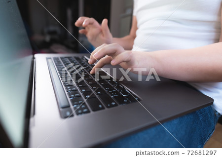 Closeup shallow depth of field of a little girl's hand on a laptop keyboard. The concept of using the younger generation of gadgets Closeup shallow depth of field of a little girl's hand on a laptop keyboard. The concept of using the younger generation of gadgets 72681297
