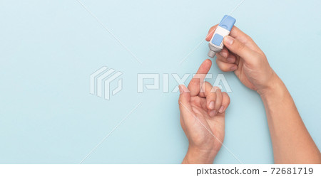 Man using lancet for diabetes 72681719
