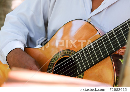 Man playing an acoustic guitar  72682613
