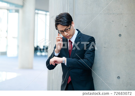 穿著西裝在辦公室裡呼籲智能手機的商人 72683072
