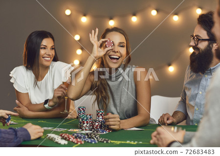 Group of smiling friends playing board games with chips at home Group of smiling friends playing board games with chips at home 72683483