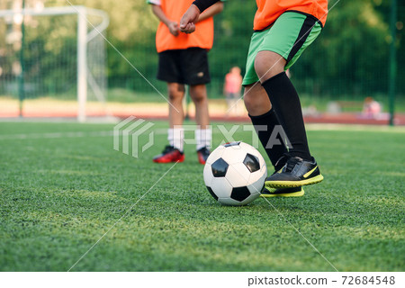 Soccer player kicking ball on field. Soccer players on training session. Close up footballer feet kicking ball on grass. Soccer player kicking ball on field. Soccer players on training session. Close up footballer feet kicking ball on grass. 72684548