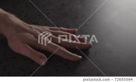 young man hand finger tap on terrazzo countertop with dim light young man hand finger tap on terrazzo countertop with dim light 72685094